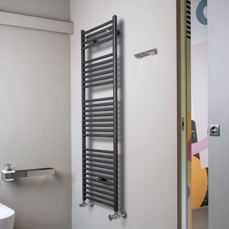 Chrome hot water towel radiator with towels in a bathroom