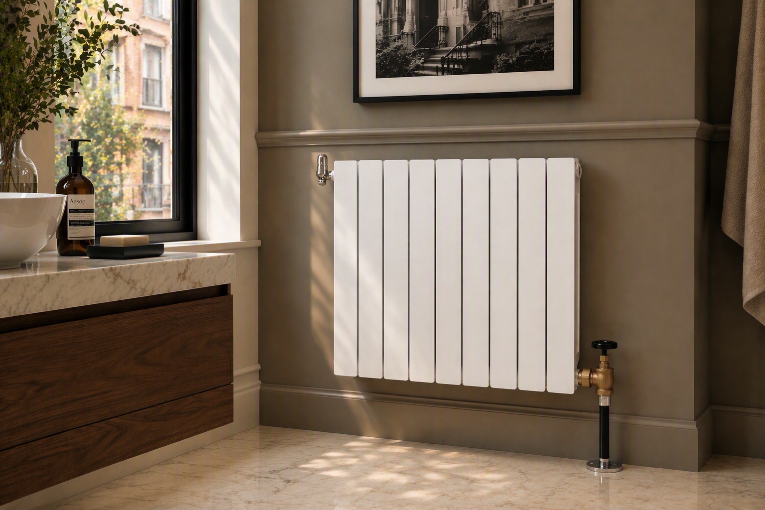 White Fondital flat-panel radiator on a taupe wall beside a marble-topped walnut vanity